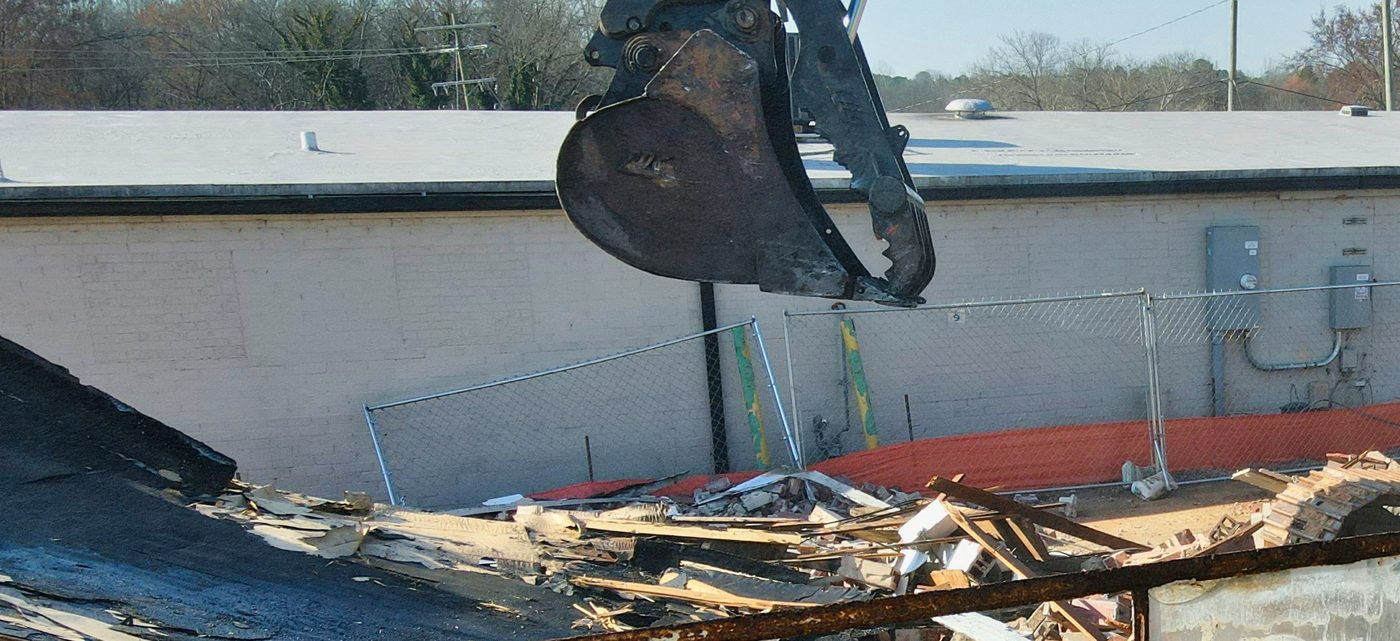 Baggergreifer über Abbruchschutt auf einer Rückbaustelle